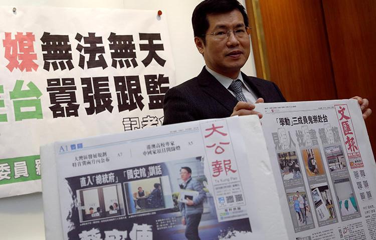 Democratic Progressive Party lawmaker Lo Chih Cheng poses with copies of Hong Kong's Ta Kung Pao and Wen Wei Po newspapers after a news conference, in Taipei, Taiwan, on January 18, 2019. (Tyrone Siu/Reuters)