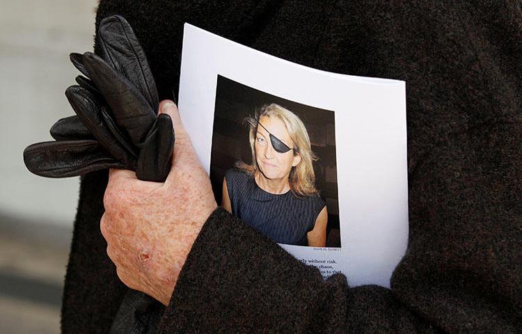 A man holds a sign honoring Sunday Times journalist Marie Colvin after a memorial service in London in 2012. A U.S. court ruled on January 30, 2019, that the Syrian government deliberately killed her. (Reuters/Stefan Wermuth)