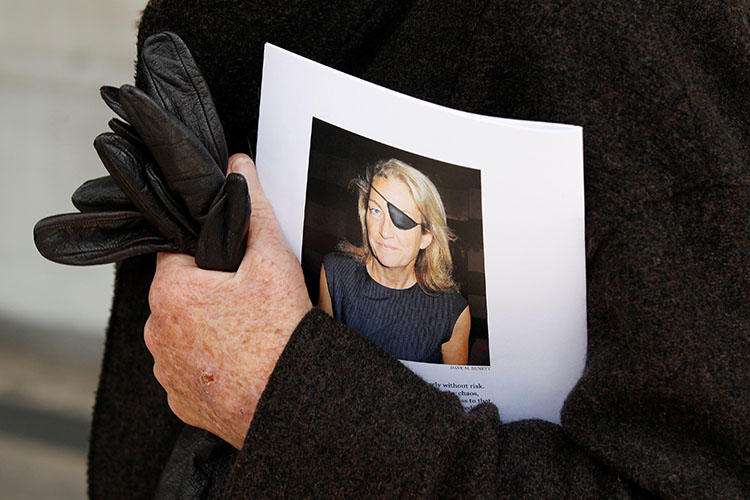 A man holds a sign honoring Sunday Times journalist Marie Colvin after a memorial service in London in 2012. A U.S. court ruled on January 30, 2019, that the Syrian government deliberately killed her. (Reuters/Stefan Wermuth)