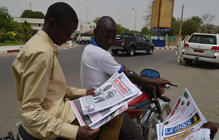 A man reads a newspaper in street in N'djamena, Chad, on April 12, 2016. A publisher was recently handed a suspended jail term in a defamation suit involving the president's brother. (Issouf Sanogo/AFP)