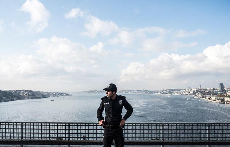 A police officer stands guard on a bridge during the 2018 Istanbul marathon. Two journalists were detained after separate raids in the city in February 2019. (AFP/Bulent Kilic)