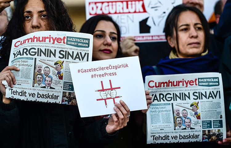 Protesters hold copies of Turkish daily newspaper Cumhuriyet during a demonstration in front of a courthouse in Istanbul on October 31, 2017. Today, the Istanbul appeals court rejected several appeals relating to the Cumhuriyet case. (Yasin Akgul/AFP)