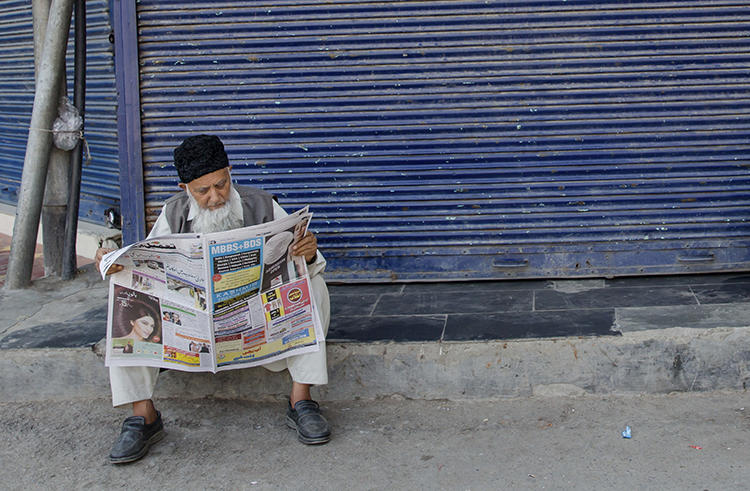 A Kashmiri man reads a newspaper in Srinagar on August 31, 2018. The Kashmiri state government recently removed lucrative advertising from two leading dailies in the region. (Dar Yasin/AP)