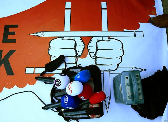 Broadcast equipment is placed on a poster during a protest in Istanbul in October 2017 over Turkey's press freedom crackdown. CPJ is joining a call for Turkish authorities to release all journalists jailed for their work. (AP/Lefteris Pitarakis)