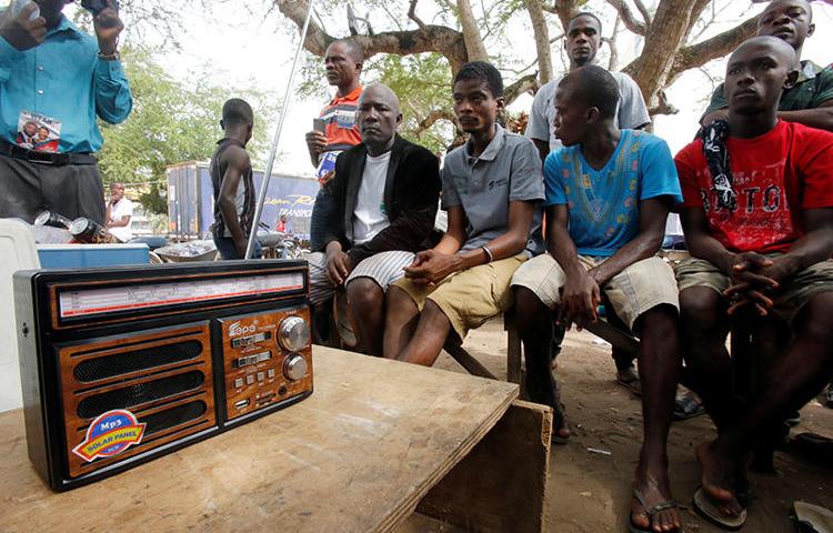 People listen to a radio in Monrovia, Liberia, on December 27, 2017. The Roots FM radio station in Monrovia was recently attacked in two separate incidents. (Thierry Gouegnon/Reuters)