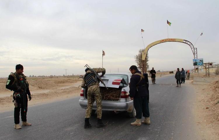 Afghan policemen search passengers at a checkpoint in Helmand province on December 17, 2017. A journalist in Helmand was recently injured by a car bomb in an assassination attempt. (Noor Mohammad/AFP)