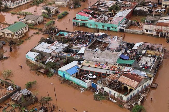 Moradores ficam em telhados em uma área inundada de Buzi, no centro de Moçambique, em 20 de março de 2019, após a passagem do ciclone Idai. (AFP/Adrien Barbier)