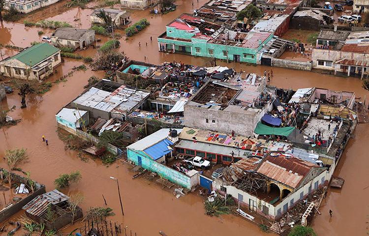Residents stand on rooftops in a flooded area of Buzi, central Mozambique, on March 20, 2019, after the passage of cyclone Idai. (AFP/Adrien Barbier)