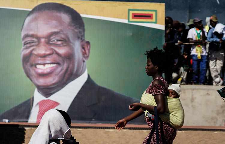 A woman walks in front of a picture of President Emmerson Mnangagwa in Bulawayo, in June 2018. Authorities in the Zimbabwean city detained documentary filmmaker Zenzele Ndebele on March 21. (AFP/Zinyange Auntony)