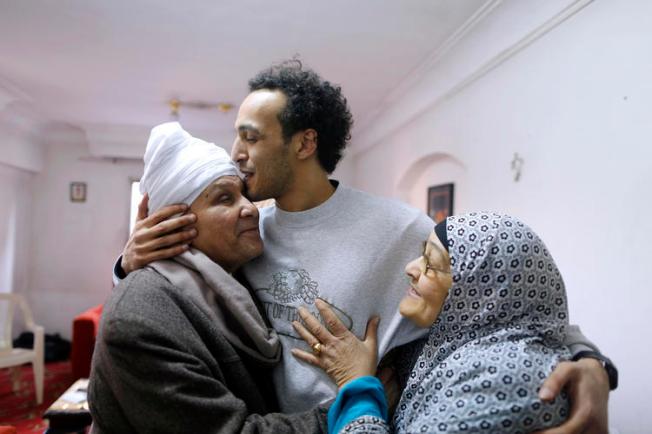 Egyptian photojournalist Mahmoud Abou Zeid, also known as Shawkan, center, is hugged by his parents at his home in Cairo, Egypt, Monday, March 4, 2019. Shawkan was released after five years in prison. (AP Photo/Amr Nabil)