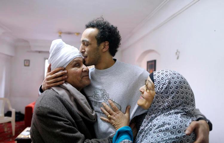 Egyptian photojournalist Mahmoud Abou Zeid, also known as Shawkan, center, is hugged by his parents at his home in Cairo, Egypt, Monday, March 4, 2019. Shawkan was released after five years in prison. (AP Photo/Amr Nabil)