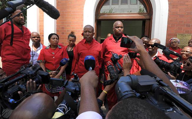 Members of the Economic Freedom Fighters (EFF) speak to the press in Cape Town, South Africa, on February 15, 2018. EFF leader Julius Malema doxxed prominent South African journalist Karima Brown on March 5, 2019, and she was later threatened, allegedly by party supporters. (AP Photo/Nasief Manie)