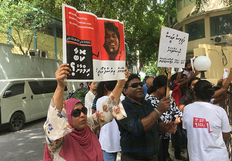 Fathimath Shehenaz holds a sign outside the Malé parliament in February, calling for justice for her brother, the blogger Ahmed Rilwan, who was abducted in 2014. (CPJ)
