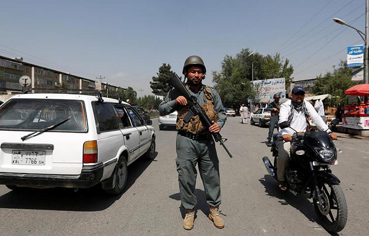An Afghan police officer inspects vehicles at a checkpoint in Kabul on August 6, 2017. An Afghan journalist was recently killed when he was shot by two unidentified men in Khost. (Mohammad Ismail/Reuters)