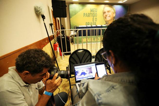 Journalists follow a Facebook Live of Jair Bolsonaro, far-right lawmaker and presidential candidate of the Social Liberal Party (PSL), in Rio de Janeiro, Brazil, October 7, 2018. After taking office in January, Bolsonaro and his supporters have made Brazilian journalists' jobs more difficult. (Reuters/Sergio Moraes)