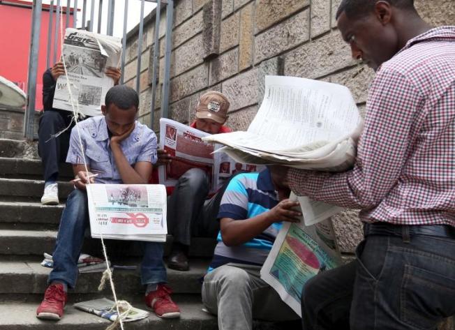 People read newspapers in Ethiopia's capital, Addis Ababa, on May 22, 2015. Two journalists were recently detained and attacked while reporting in Legetafo, a town in Ethiopia's Oromia region. (Tiksa Negeri/Reuters)