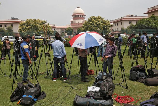 Television journalists are seen outside the premises of the Supreme Court in New Delhi, India, August 22, 2017. The Indian government threatened to invoke Official Secrets Act against two news outlets on March 6, 2019. (Reuters/Adnan Abidi)