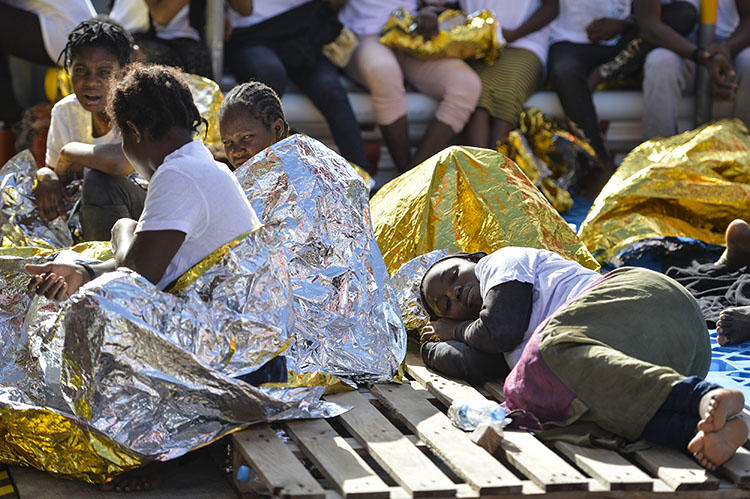 Women rest on a ship run by the Maltese non-governmental group Moas and the Italian Red Cross after a rescue operation in the Mediterranean in November 2016. In Italy, journalists say they are regularly harassed and threatened online over their coverage of migration issues. (AFP/Andreas Solaro)