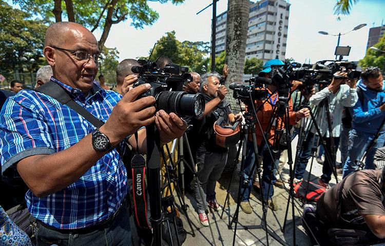 Jornalistas cobrem a libertação de cinco colegas detidos em Caracas em janeiro. O número de detenções arbitrárias de jornalistas locais e estrangeiros que cobrem a crise política e econômica da Venezuela está aumentando.  (AFP/Juan Barreto)