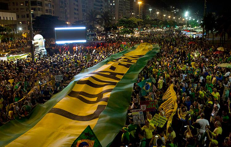Demonstrators extend a banner in the colors of Brazil's flag during a protest against Brazil's former President Luiz Inacio Lula da Silva in Rio de Janeiro, Brazil, on April 3, 2018. A Brazilian court ordered online magazine Crusoé to remove an article about a judge on April 15, 2019. (AP Photo/Silvia Izquierdo)
