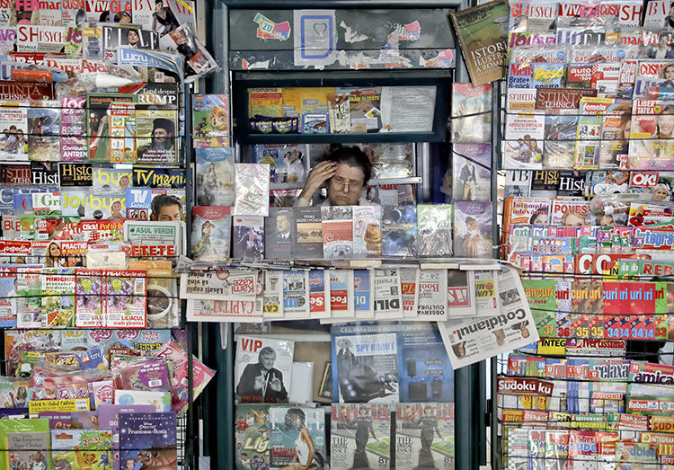 A newspaper vendor is seen in Bucharest, Romania, on May 30, 2017. Romanian reporter Emilia Șercan recently received death threats relating to her work. (AP/Vadim Ghirda)