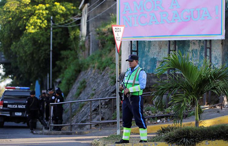 Un funcionario policial mantiene guardia en las oficinas de 100% Noticias en Managua, Nicaragua el 22 de diciembre de 2018. El juicio de los periodistas Lucía Pineda y Miguel Mora fue recientemente suspendido sin fijarse nueva fecha. (Reuters/Oswaldo Rivas)