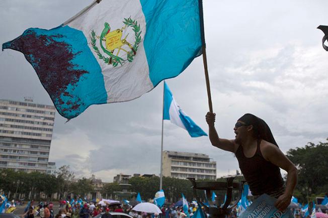 Un hombre ondea la bandera nacional de Guatemala durante una protesta en Ciudad de Guatemala. El país tiene previsto celebrar elecciones presidenciales y legislativas en Junio. (AP/Moisés Castillo, archivo) (AP/Moises Castillo, File)