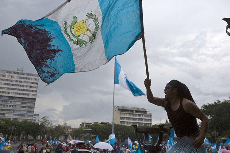 A man waves a Guatemalan national flag during a protest in Guatemala City. The country is due to hold presidential and congressional elections in June. (AP/Moises Castillo, File)
