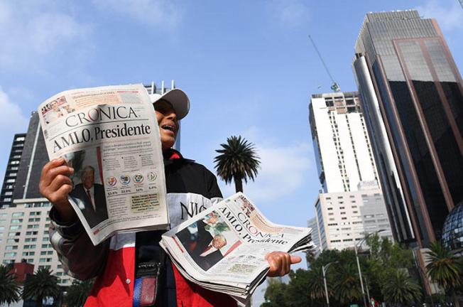 A vendor sells newspapers showing the results of Mexico's presidential elections, in Mexico City, in July 2018. Mexico's new government has said it will address the opaque practice of government advertising in media. (AFP/Ulises Ruiz)