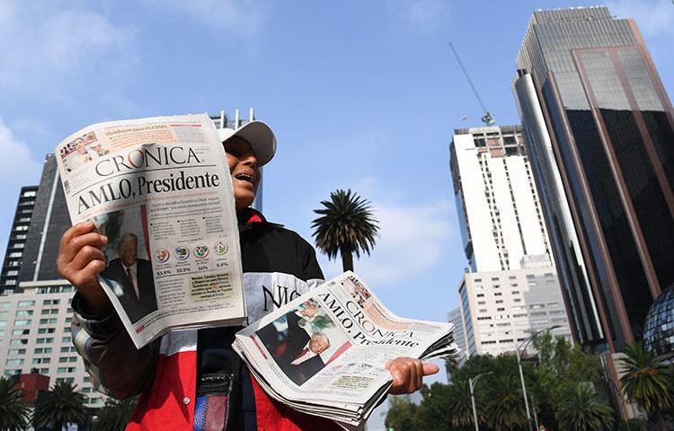 A vendor sells newspapers showing the results of Mexico's presidential elections, in Mexico City, in July 2018. Mexico's new government has said it will address the opaque practice of government advertising in media. (AFP/Ulises Ruiz)