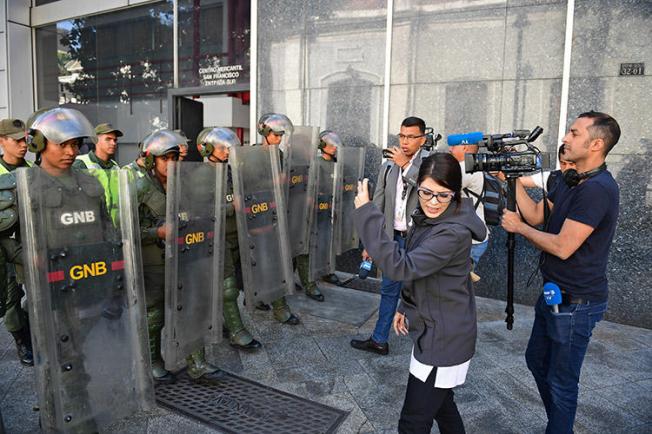 Members of the press and the Bolivarian National Guard, pictured outside the Federal Legislative Palace, in Caracas, on May 15, 2019. Local and international journalists say there are several challenges to covering the Venezuela crisis. (AFP/Ronaldo Schemidt)