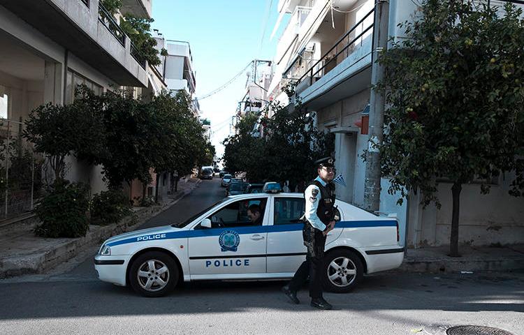 Police officers are seen in Athens, Greece, on November 13, 2018. CNN Greek reporter Mina Karamitrou's car was recently destroyed by a bomb in an Athens suburb. (AP/Petros Giannakouris)