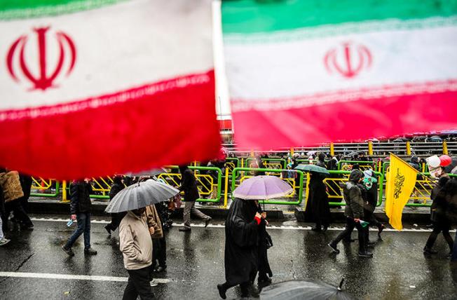 People carry umbrellas in Tehran, Iran, on February 11, 2019. On May 1, two journalists were arrested while covering Labor Day demonstrations in Tehran. (Vahid Ahmadi/Tasnim News Agency via Reuters)