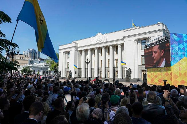 People gather in front of the Ukrainian parliament during the inauguration on May 20, 2019, of President Volodymyr Zelenskiy, who campaigned on an anti-corruption platform. Cherkasy-based journalist Vadym Komarov, known for reporting on local corruption, died June 20 as the result of an assault six weeks earlier. (AP/Evgeniy Maloletka)
