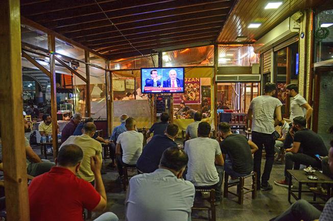 People watch a live broadcast of a televised debate between Istanbul's mayoral candidates at a tea house in Diyarbakir on June 16, 2019. (AFP/Ilyas Akengin)
