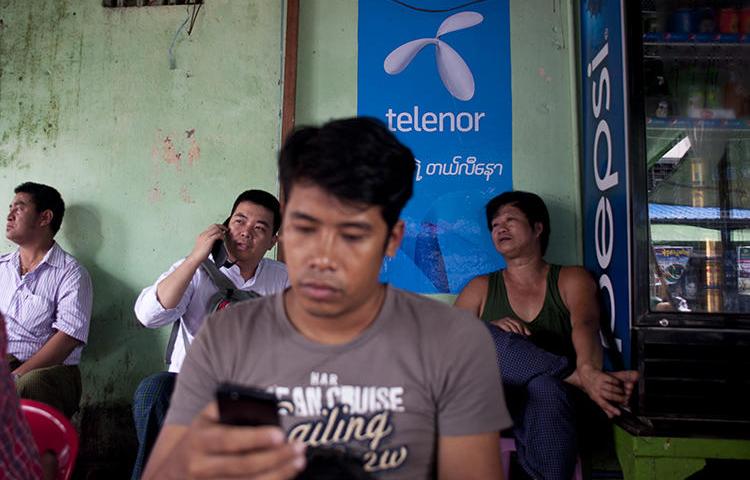 A man uses a cellphone in Yangon, Myanmar, on September 26, 2014. The government recently cut mobile internet access to Rakhine and Chin states. (AFP/Ye Aung Thu)