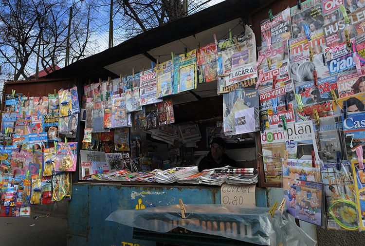 A man waits for customers in a news kiosk in Bucharest, Romania, on March 22, 2011. Romanian investigative journalist Diana Oncioiu received an anonymous death threat on June 11, 2019. (AFP/Daniel Mihailescu)