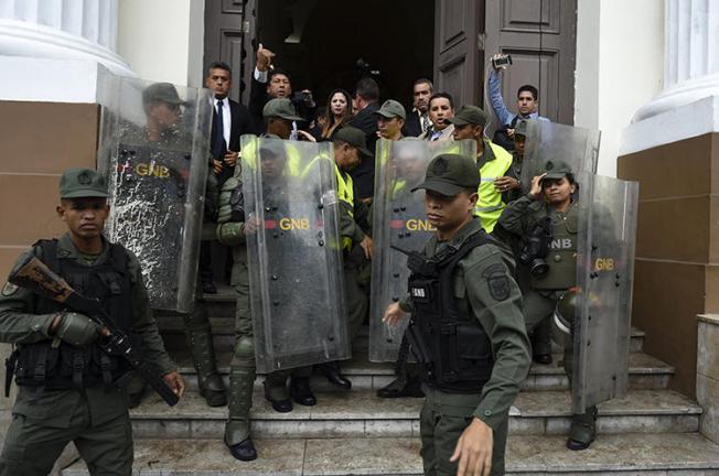Miembros de la Guardia Nacional Bolivariana impiden a los periodistas entrar a la Asamblea Nacional, en Caracas, Venezuela, el 18 de junio de 2019. Los oficiales han bloqueado la entrada de los periodistas al edificio de la Asamblea durante los debates celebrados los días martes, desde el 7 de mayo. (AFP/Yuri Cortez)