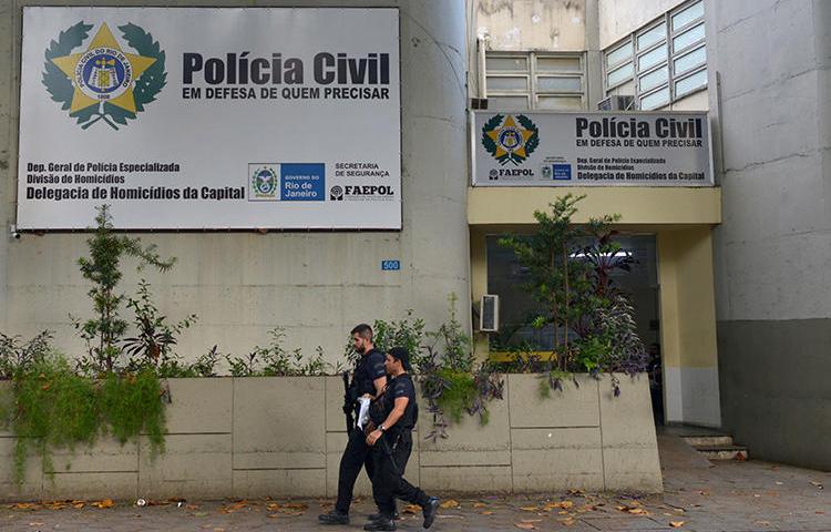 Policiais caminham em frente ao departamento de homicídios no Rio de Janeiro, Brasil, em 13 de março de 2019. O jornalista Romário Barros foi morto recentemente em Maricá, no estado do Rio de Janeiro. (Reuters / Lucas Landau)