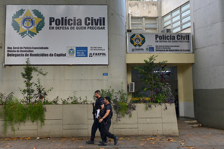 Policiais caminham em frente ao departamento de homicídios no Rio de Janeiro, Brasil, em 13 de março de 2019. O jornalista Romário Barros foi morto recentemente em Maricá, no estado do Rio de Janeiro. (Reuters / Lucas Landau)