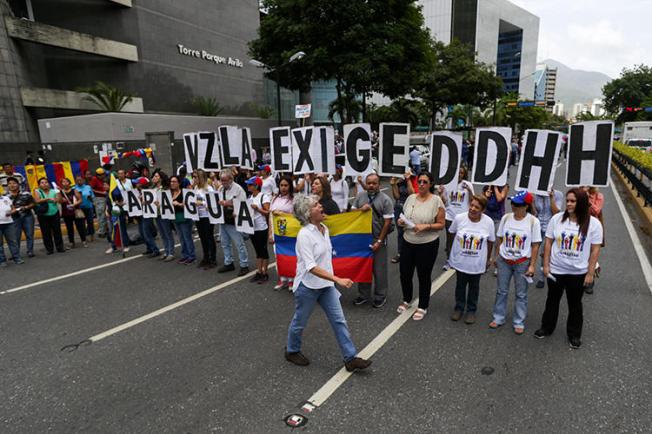 Opposition supporters demonstrate outside the headquarters of the U.N. Development Programme during the visit of UN High Commissioner for Human Rights Michelle Bachelet, in Caracas on June 21, 2019. Venezuelan journalist Braulio Jatar was conditionally released from house arrest on July 8, 2019, and barred from the leaving country. (AFP/Cristian Hernandez)