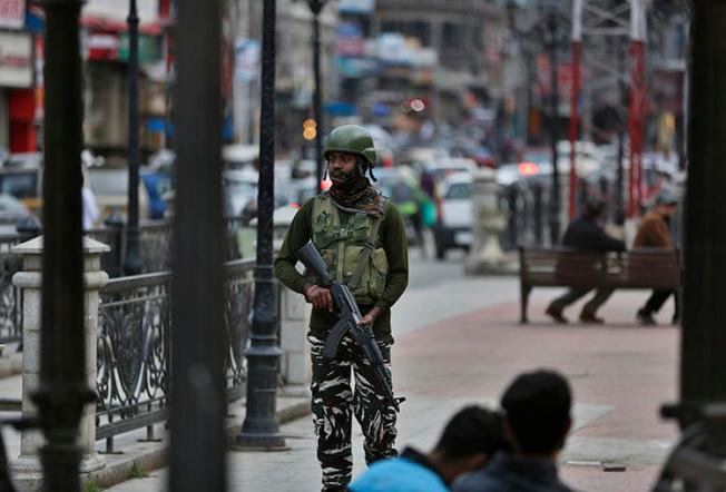 An Indian paramilitary soldier stands guard in Srinagar, Indian-controlled Jammu and Kashmir, on June 12, 2019. India's National Investigation Agency questioned Greater Kashmir editor Fayaz Kaloo for six days in early July. (AP Photo/Mukhtar Khan)