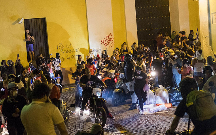 Demonstrators demanding the resignation of Gov. Ricardo Rosselló arrive on motorcycles in San Juan, Puerto Rico, on July 18, 2019. Thousands of people are calling on Rosselló to resign after the leak of online chats that show him making misogynistic slurs and mocking his constituents. (AP/Dennis M. Rivera Pichardo)
