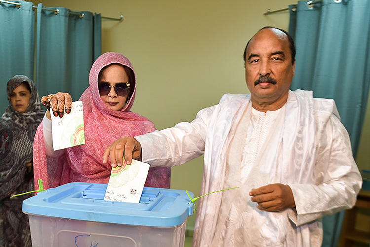 Mauritanian President Mohamed Ould Abdel Aziz (right) casts his ballot on June 22, 2019, at a polling station in Nouakchott during the presidential election. Mauritania freed blogger Mohamed Cheikh Ould Mohamed, who had been imprisoned since 2014, on July 29, 2019. (AFP/Sia Kambou)