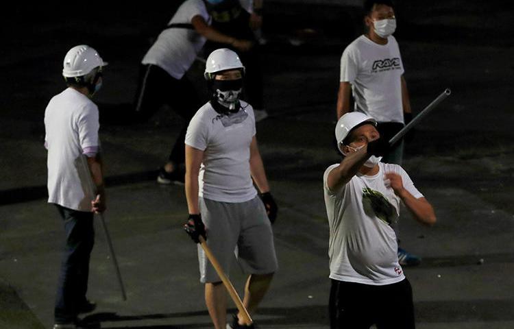 Men with poles are seen after attacking journalists and anti-extradition bill demonstrators at a train station in Hong Kong on July 22, 2019. (Reuters/Tyrone Siu)