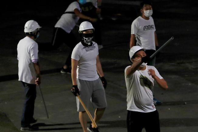 Men with poles are seen after attacking journalists and anti-extradition bill demonstrators at a train station in Hong Kong on July 22, 2019. (Reuters/Tyrone Siu)