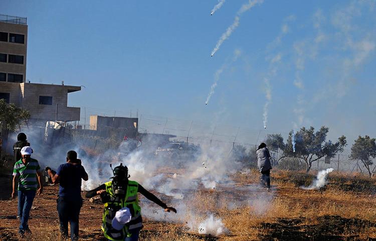 Journalists and demonstrators are seen in the West Bank on July 20, 2019. On July 19 and 20, at least three Palestinian journalists were injured by Israeli soldiers while covering protests in Gaza and the West Bank. (Reuters/Mussa Qawasma)