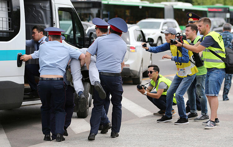 Police officers detain an opposition supporter as journalists take pictures during a protest against presidential election results in Almaty, Kazakhstan, June 10, 2019. The blocking of news websites during the leadership transition suggests that recent moves to control the internet are about censorship, not security. (Reuters/Pavel Mikheyev)