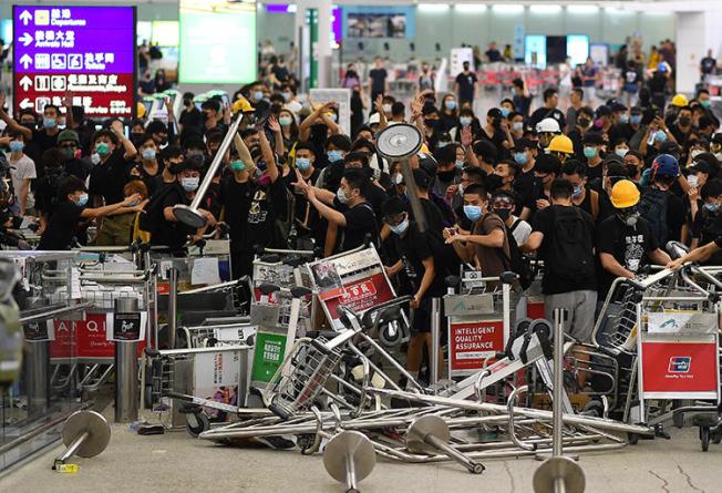 Pro-democracy protesters block the entrance to the airport terminals at Hong Kong's international airport on August 13, 2019. The protesters that day assaulted a journalist from China’s Global Times at the airport. (AFP/Manan Vatsyayana)