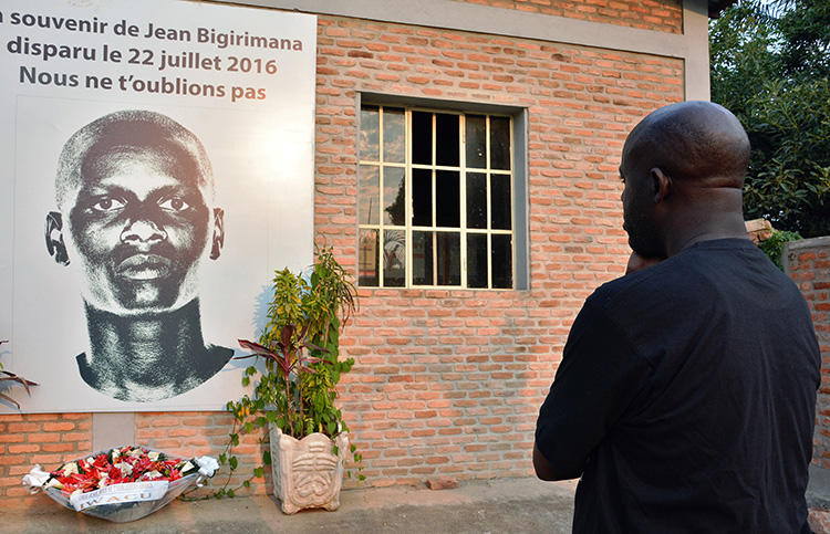 A man stands in front of a plaque in honor of missing Burundian journalist Jean Bigirimana in Bujumbura during a commemoration to mark one year after the journalist's disappearance on July 21, 2017. On August 2, 2019, CPJ joined a call for the U.N. Human Rights Council to extend the mandate of the Burundi Commission of Inquiry. (AFP/STRINGER)